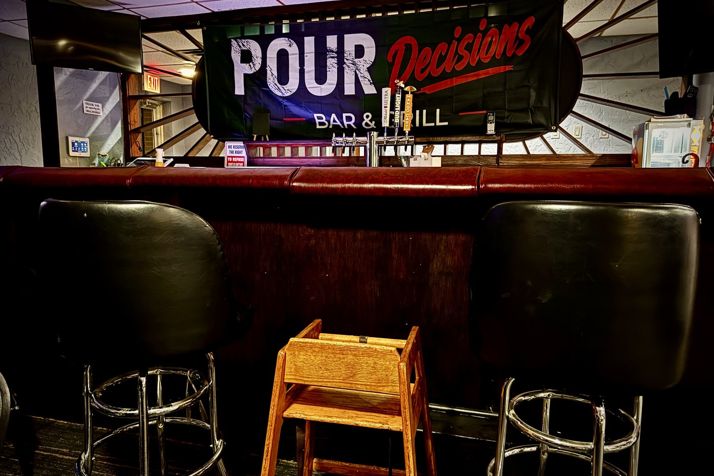 Vinyl banner over the taps. Read across the room, in bar lighting.
